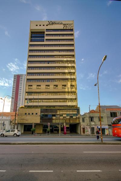 a tall building on the side of a city street at Victoria Villa Curitiba in Curitiba