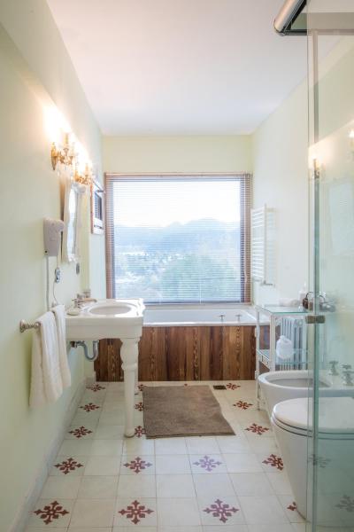 baño con lavabo, bañera y ventana en Paraíso Casa de Montaña en San Martín de los Andes