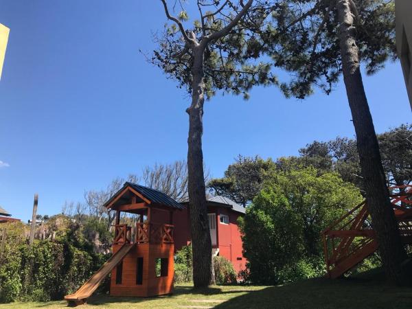 una casa en un árbol con un tobogán en un patio en Cepas de Mar Resort & Wine en Las Gaviotas