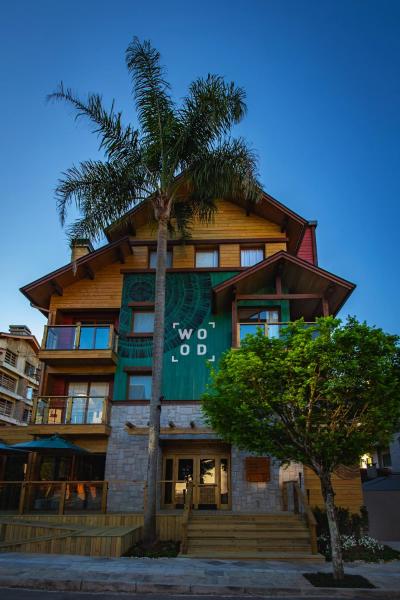 un edificio con una palmera delante de él en Wood Hotel, en Gramado