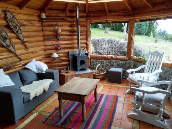 Sala de estar de una cabaña de madera con mesa y sillas en Albatros cabaña, en Villa La Angostura