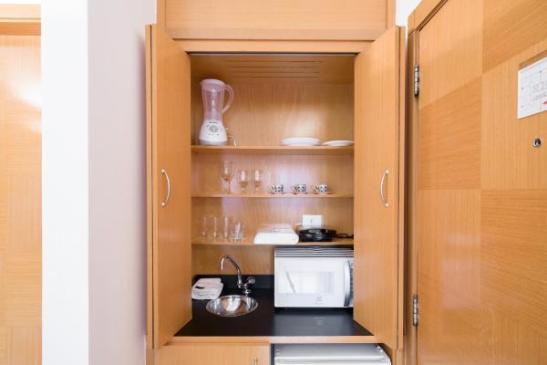 una cocina con un armario lleno de electrodomésticos y una cocina en BHomy Jardins Conforto na Alameda Lorena TU705, en São Paulo
