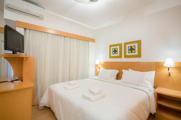 1 dormitorio con 1 cama blanca grande y Tv LED en BHomy Jardins Conforto na Alameda Lorena TU705, en São Paulo
