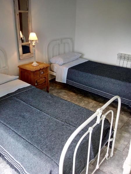 1 dormitorio con 2 camas y mesa con lámpara en DTO SERRANO en Tandil