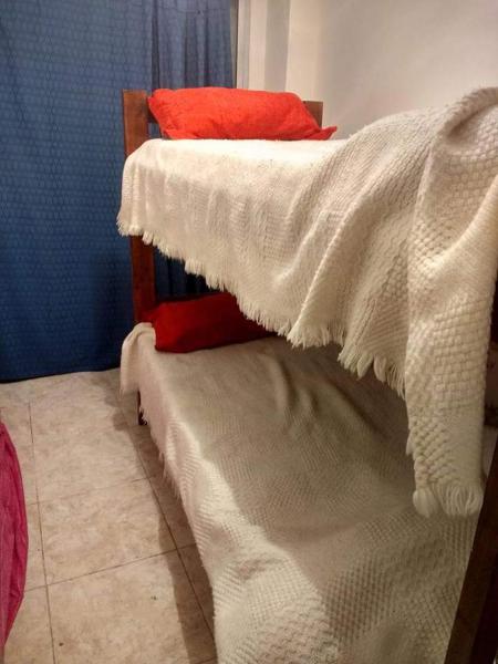 1 dormitorio con 2 literas y mantas blancas en el cabo frente al mar en Mar del Plata