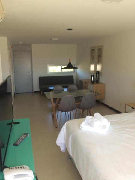 1 dormitorio con 1 cama y comedor con mesa en Dos Orillas Monoambiente 412, en Colonia del Sacramento