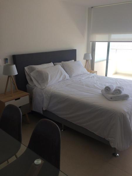 1 dormitorio con 1 cama con 2 toallas en Dos Orillas Monoambiente 412, en Colonia del Sacramento