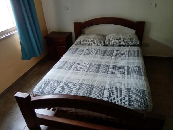 1 dormitorio con 1 cama con cabecero de madera en Casa Fleming, en Villa Carlos Paz
