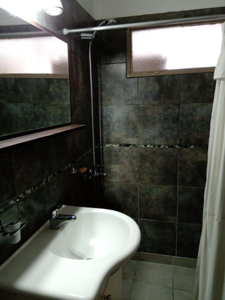 y baño con lavabo y ducha. en Casa Fleming, en Villa Carlos Paz