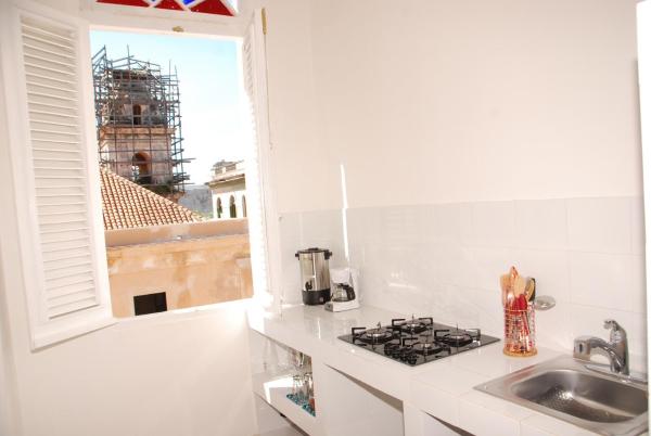 cocina blanca con fregadero y ventana en Casa Violeta, en La Habana