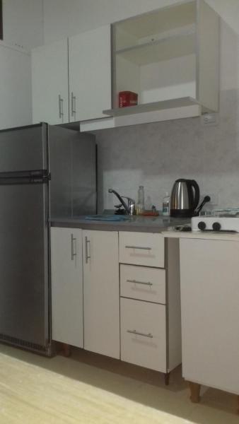 cocina con armarios blancos y refrigerador negra en Depto en PH Planta baja al Frente en Buenos Aires