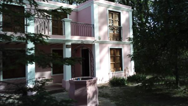 una casa rosa con ventana y balcón en el marratxi de Villa Gesell