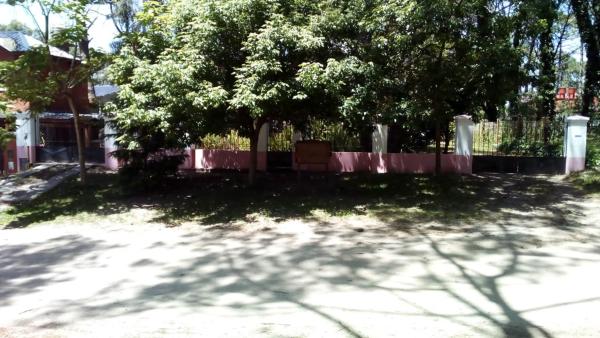 un cementerio con un árbol y una valla al marrachi de Villa Gesell
