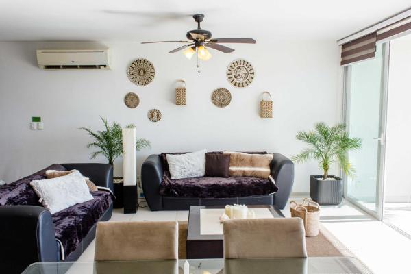sala de estar con 2 sofás y ventilador de techo en AMARA CANCUN BEaCHFRONT CARIBE 1, en Cancún