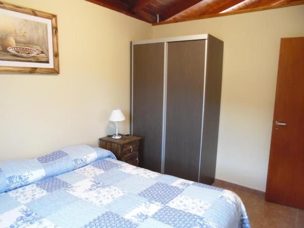Un dormitorio con una cama azul y blanca y un armario en Cabañas Doña Itati, en Villa Carlos Paz