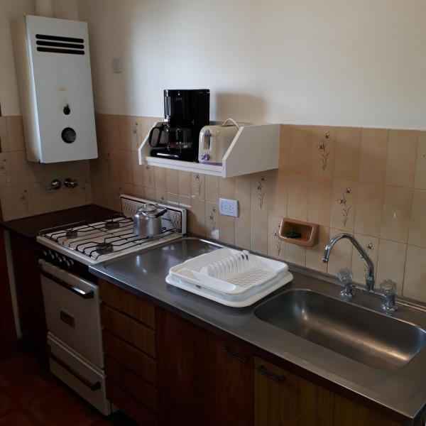 cocina con fregadero y encimera horno superior en Departamentos Bezbel - Mariska en Villa Gesell