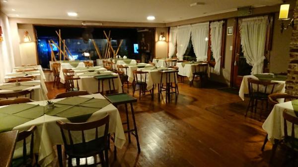 un restaurante con mesas y sillas con mantel blanco en Hosteria Actinia en Villa Gesell