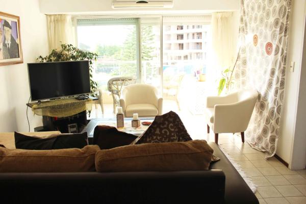 sala de estar con sofá y Tv LED en Apartamento en Punta del Este Playa Mansa, en Punta del Este