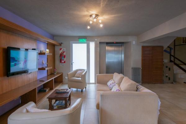 sala de estar con 2 sofás y Tv LED en Hotel Victoria en Pinamar