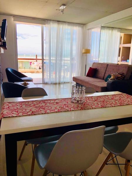 sala de estar con mesa con sillas y sofá en Linda Bay Beach & Resort Spa en Mar de las Pampas