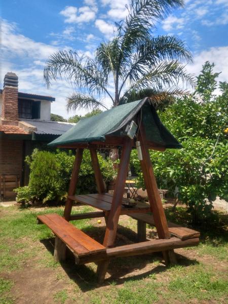 mesa de picnic de madera con techo verde en la parte superior en Zahra Depto en Villa Gesell