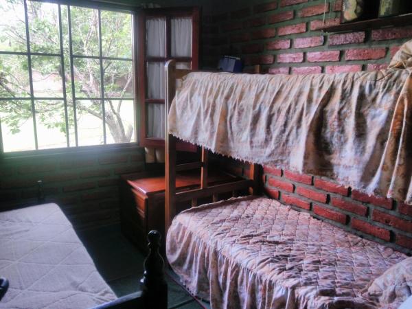 1 dormitorio con cama y pared de ladrillo en ALOJAMIENTO VALLE DE SALTA en Salta