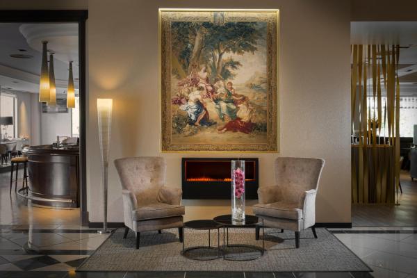 una sala de estar con 2 sillas y una pintura en la pared en Elba Madrid Alcalá, en Madrid