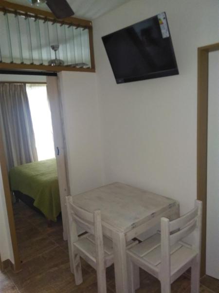 Habitación con mesa y TV en la pared. en Estudio en Edificio Olagüe en Mar del Plata