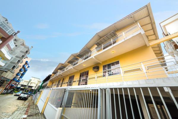 un edificio amarillo con balcón en una calle en Residencial Kelly Cristina, en Bombinhas