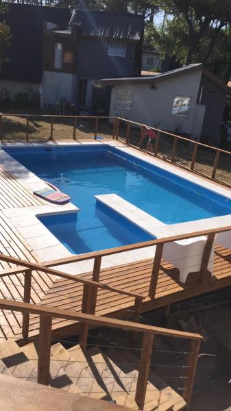 una gran piscina en una terraza con una mesa de madera en Brisas del Mar, en Mar Blava