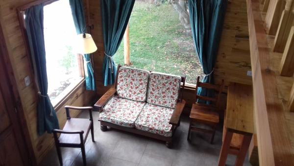 Habitación con 2 sillas, mesa y ventana a Cabañas Villa Centauro en San Carlos de Bariloche