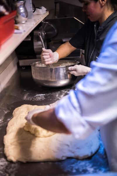 una persona en una cocina haciendo un buñuelo en Los Naranjos de Ushuaia