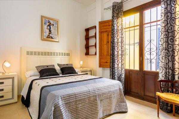 1 dormitorio con cama y ventana en HSH Suites Barrio Santa Cruz, en Sevilla