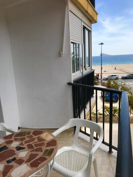 una mesa y una silla en un balcón con vistas a la playa en Neptuno on the Beach, en Benidorm