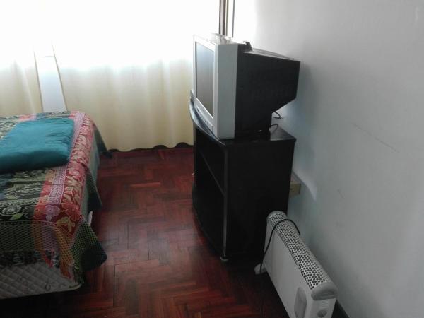 TV en un stand en una habitación con cama en Andinas Mendoza en Mendoza