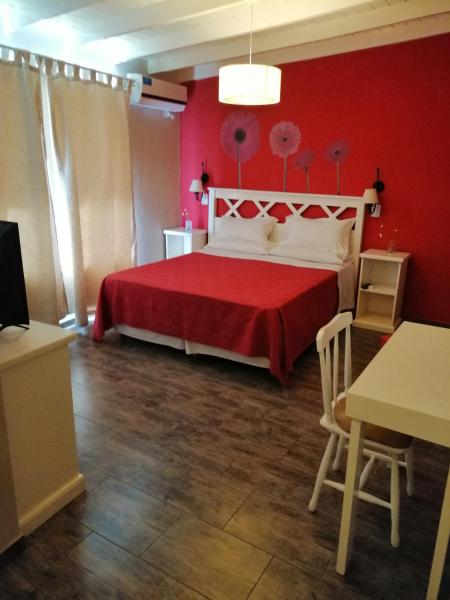 1 dormitorio rojo con 1 cama y pared roja en Hosteria Magnolia en Villa Gesell