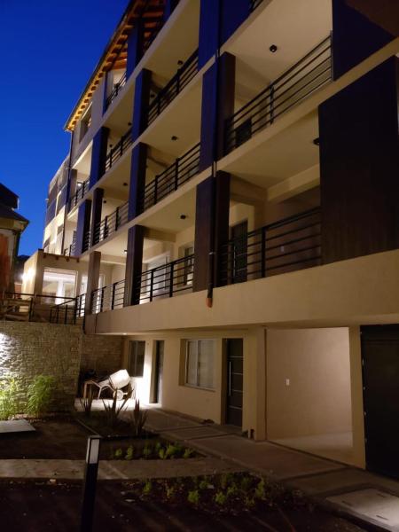 un gran edificio de apartamentos por la noche con balcón en Moderno departamento en Av. San Martín en San Martín de los Andes