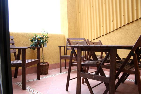 una mesa de madera y sillas junto a una pared en Groc Fluvia, en Barcelona