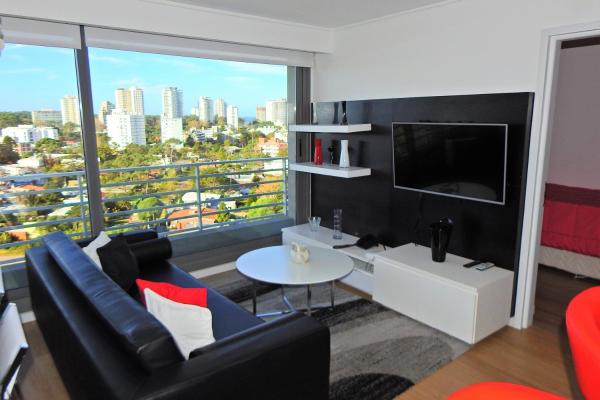 sala de estar con sofá y TV en Alexander Boulevard, en Punta del Este