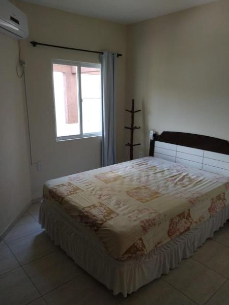 1 dormitorio con 1 cama grande y ventana en Residencial Melfi 3 Ap.5 Lateral, en Bombinhas