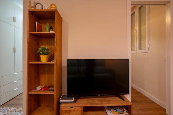 TV de pantalla plana con soporte de madera en una habitación en For You Rentals Chueca Apartment BRC42, en Madrid