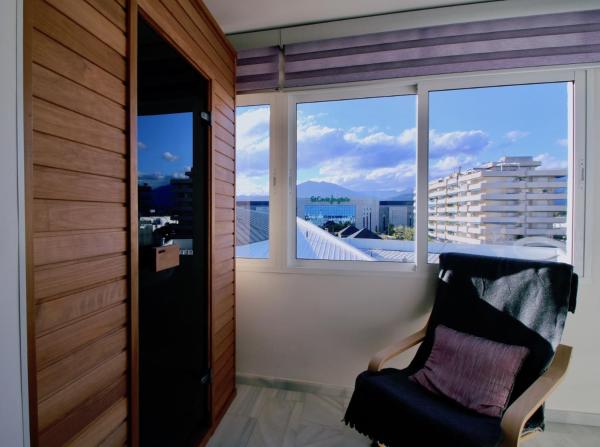 una silla sentada en una habitación con ventana en Sea View Puerto Banús Apt SAUNA + PARKING - RDR165, en Marbella