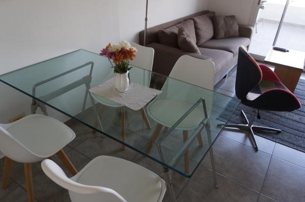 una mesa de cristal y sillas en la sala de estar. en Ático Palermo en Buenos Aires