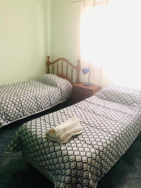 2 camas individuales en una habitación con ventana en Amplio Departamento Familiar en San José en Mendoza