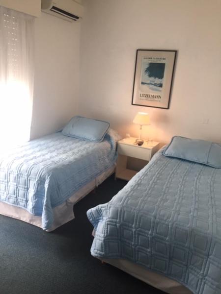 1 dormitorio con 2 camas y una lámpara en una mesa en Aqua Hotel, en Punta del Este