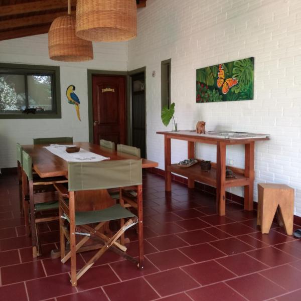 comedor con mesa, mesa y sillas en Oasis Bed and Breakfast en Puerto Iguazú