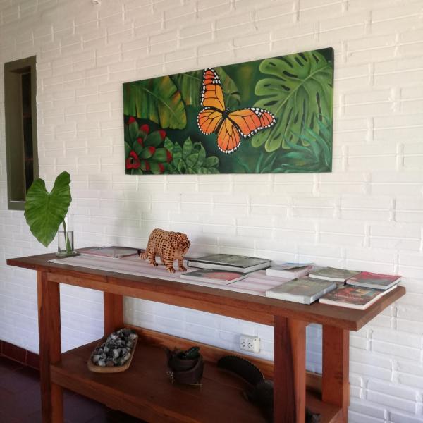 una mesa de madera con una pintura de mariposa en la pared en Oasis Bed and Breakfast en Puerto Iguazú