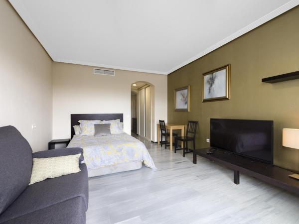 1 dormitorio con cama, sofá y TV en Studio, with Sea View, in Medina Garden - Puerto Banús, en Marbella