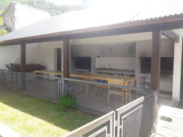 un pabellón con bancos y mesas en un patio en Depto Centrico con pequeño jardin y parrilla en San Martín de los Andes