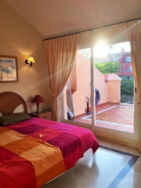 1 dormitorio con 1 cama y puerta que da a un patio en Townhouse Marbella - Banús T002, en Marbella